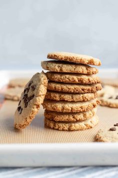 chocolate chip cookies stacked on top of each other with one cookie in the foreground