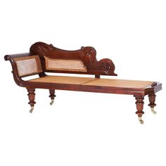 an antique wooden bench with wicker seat and back rests on casteors, isolated against a white background