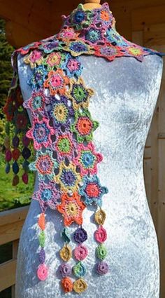 a mannequin is decorated with multicolored crocheted flowers and beads