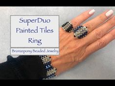 a woman's hand with two rings on it and the words superduo painted tiles