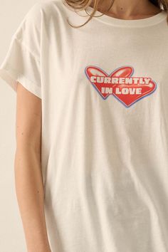 Garment washed graphic t-shirt. Vintage-style "Currently in Love" text print with heart graphics. Round neckline. Short sleeves. Drop shoulder. Relaxed fit. 100% Cotton. Imported top designed and printed in LA. Model wears size S. Heart Graphics, Text Print, Love Text, Vintage Canvas, Iron Decor, Drop Shoulder, Round Neckline, Vintage Style, Graphic T Shirt