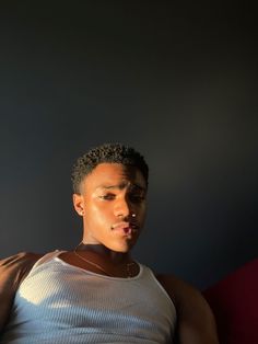 a young man sitting on top of a red couch