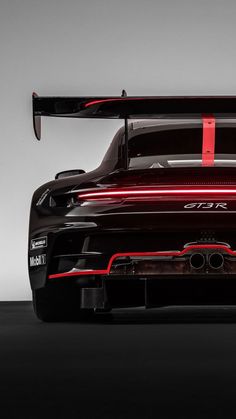 the rear end of a black sports car with red stripes on it's side