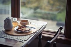 there is a plate with some food on it next to a cup and saucer