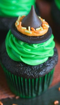 a cupcake with green frosting and a chocolate cone on top