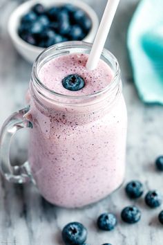 a smoothie in a mason jar with blueberries on the side