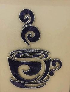 a coffee cup made out of beading on a white surface with an intricate design