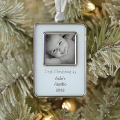 a baby's first christmas as an ornament hanging from a christmas tree