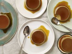 three plates with pancakes covered in syrup and spoons next to each other on a table