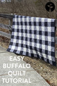 a black and white checkered quilt hanging on a fence with text overlay that reads easy buffalo quilt tutor