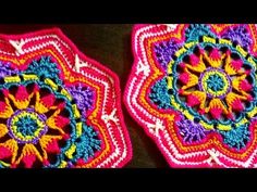 two colorful crocheted coasters sitting next to each other