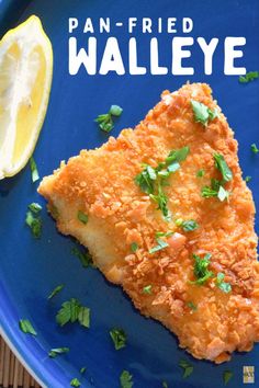 a blue plate topped with fried fish next to a lemon wedge