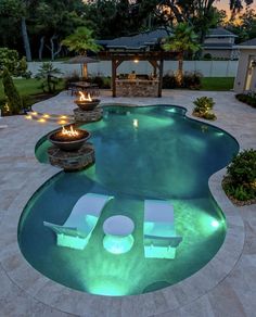 an outdoor pool with fire pit and lounge chairs