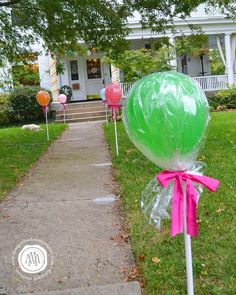 green and pink lollipops in front of a house