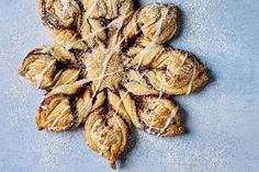 a snowflake shaped pastry sitting on top of a blue tablecloth covered in powdered sugar