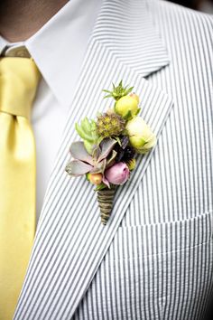 a man wearing a suit and tie with a boutonniere on his lapel