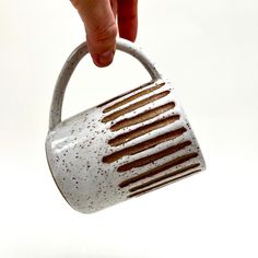 a hand holding a white and brown grater