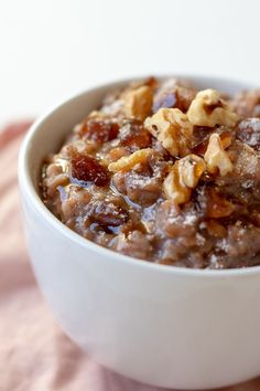 a white bowl filled with oatmeal and nuts