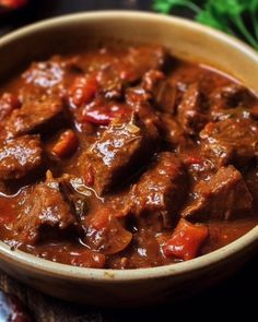 a close up of a bowl of food with meat and vegetables in it on a table