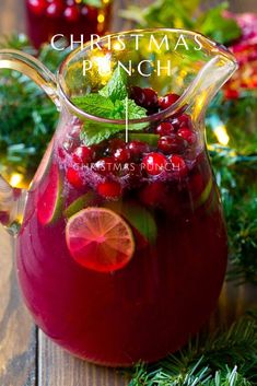 a pitcher filled with cranberry punch and garnished with fresh greenery