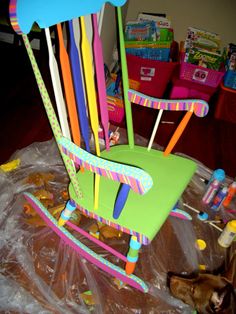 a child's plastic rocking chair with lots of colorful toothbrushes on it