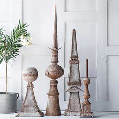 an assortment of decorative objects sitting next to a potted plant in front of a white door