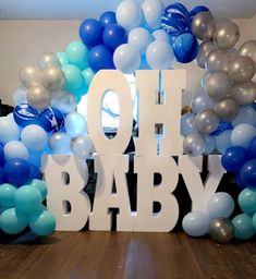 balloons and letters are arranged on the floor in front of a backdrop that says oh baby