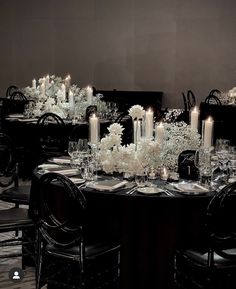 a dining room table is set with candles and flowers in centerpieces for an elegant look