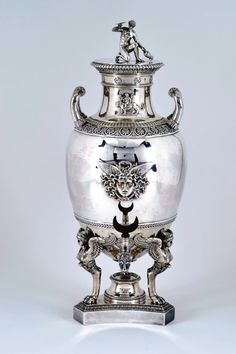 a silver urn sitting on top of a table