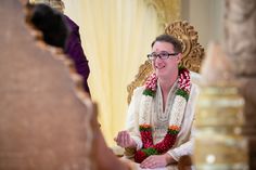 a man sitting in a chair with a lei around his neck and flowers on it