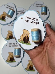 a hand holding a spool of blue thread with the words how big is my tummy?