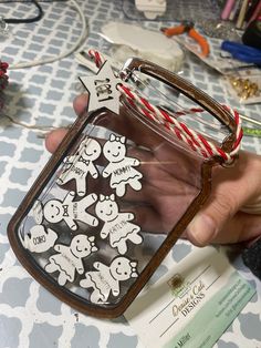 a person holding up a clear case with stickers on it and some candy canes