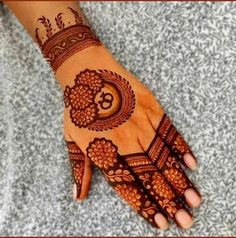 a woman's hand with henna tattoos on it