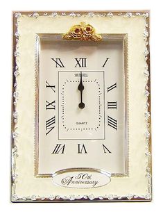 a white clock with roman numerals on it