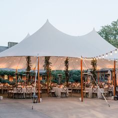 a large white tent set up with tables and chairs