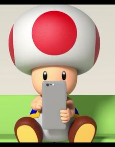 a cartoon character sitting on the ground with a tablet in front of his face and holding it