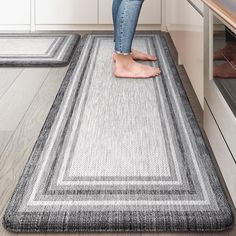 a woman standing on top of a rug in a kitchen