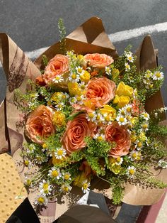 a bouquet of flowers sitting on top of a brown paper bag