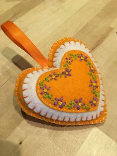 an orange and white heart shaped ornament with sprinkles on it