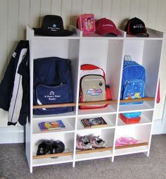 several children's backpacks and bookshelves are lined up against the wall