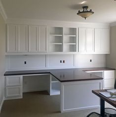 an empty office with white cabinets and desk