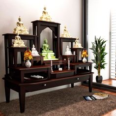 a living room scene with focus on the coffee table and buddha figurines sitting on it