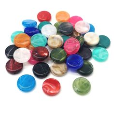 many different colored buttons on a white surface