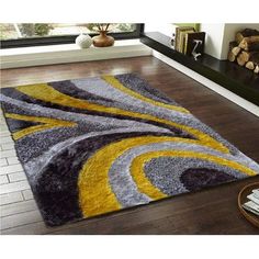 an area rug with yellow, grey and black swirls on the floor in front of a fireplace