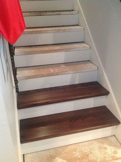 a set of stairs with wooden treads and white painted handrails in a home