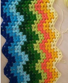 a multicolored crocheted blanket with yarn