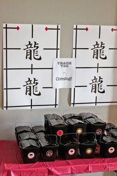 a table topped with lots of black containers filled with liquid sitting next to each other