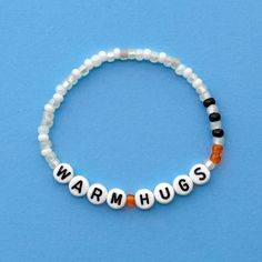 Warm Hugs bracelet! Handmade with love using Czech glass beads, white and black letter beads and stretch cord. Get creative! All my bracelets are meant to be mixed, matched & stacked!  SIZING: Measure your wrist around the widest point and add .25-.5 inches to get the most comfortable or desired fit. If you don't have a flexible tape measure, you can use a piece of string to wrap around your wrist and then measure the length of the string. (For example: my wrist size is 6" and I will wear a 6.5" bracelet for a snug fit and 7" for a loose fit). CARE INSTRUCTIONS: Please be careful to not overstretch bracelets too far. They are made out of a durable elastic string but are still capable of breaking if not handled carefully. Avoid submerging bracelets in water and store in a dry place. I'd lov