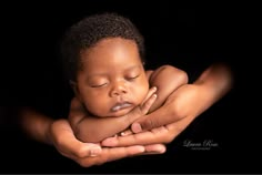 a baby sleeping in his mother's hands