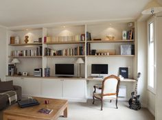 a living room filled with furniture and bookshelves next to a wall mounted tv